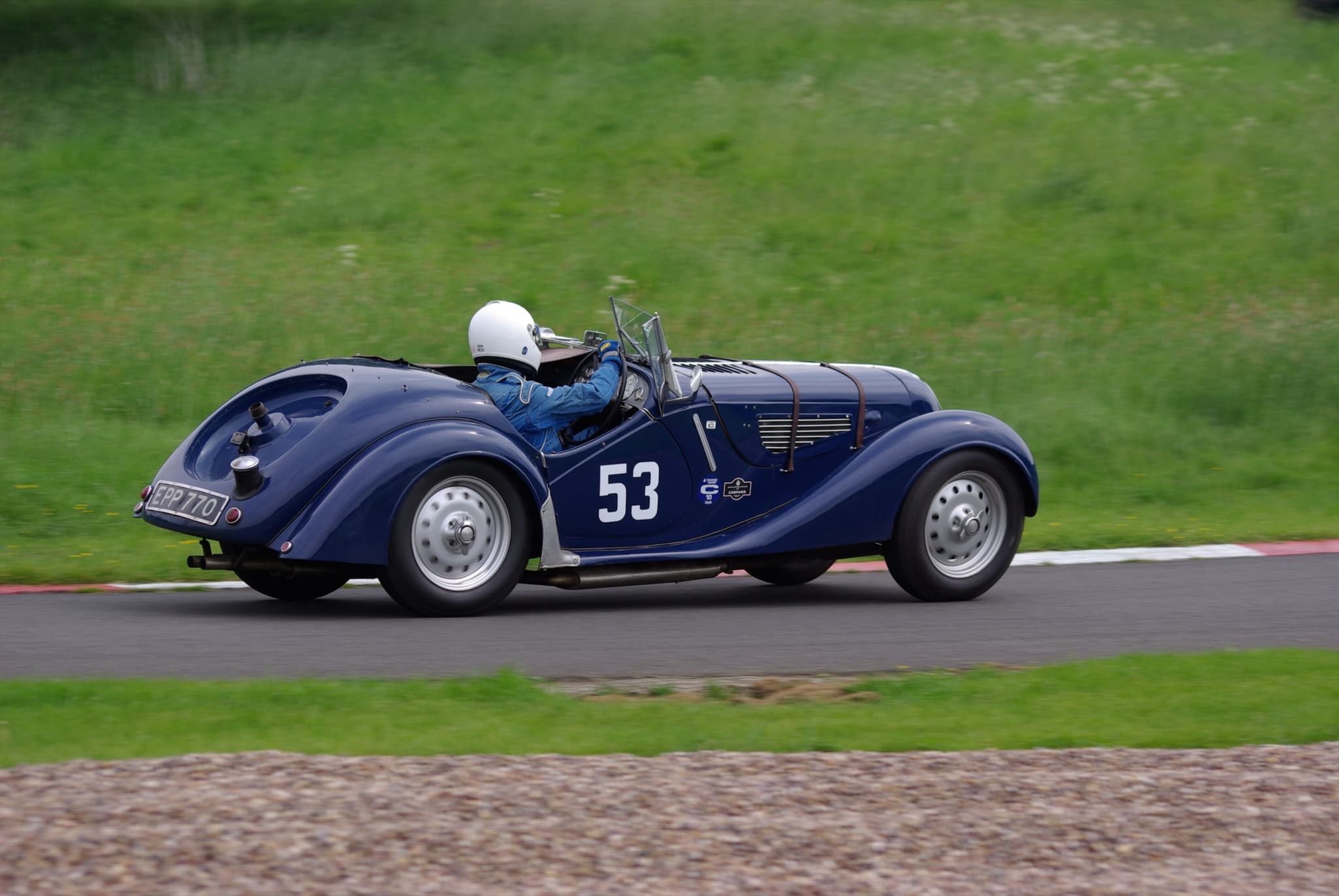 A dark-blue BMW 328 roadster with race number 53 from the right rear on a hill-climb course.