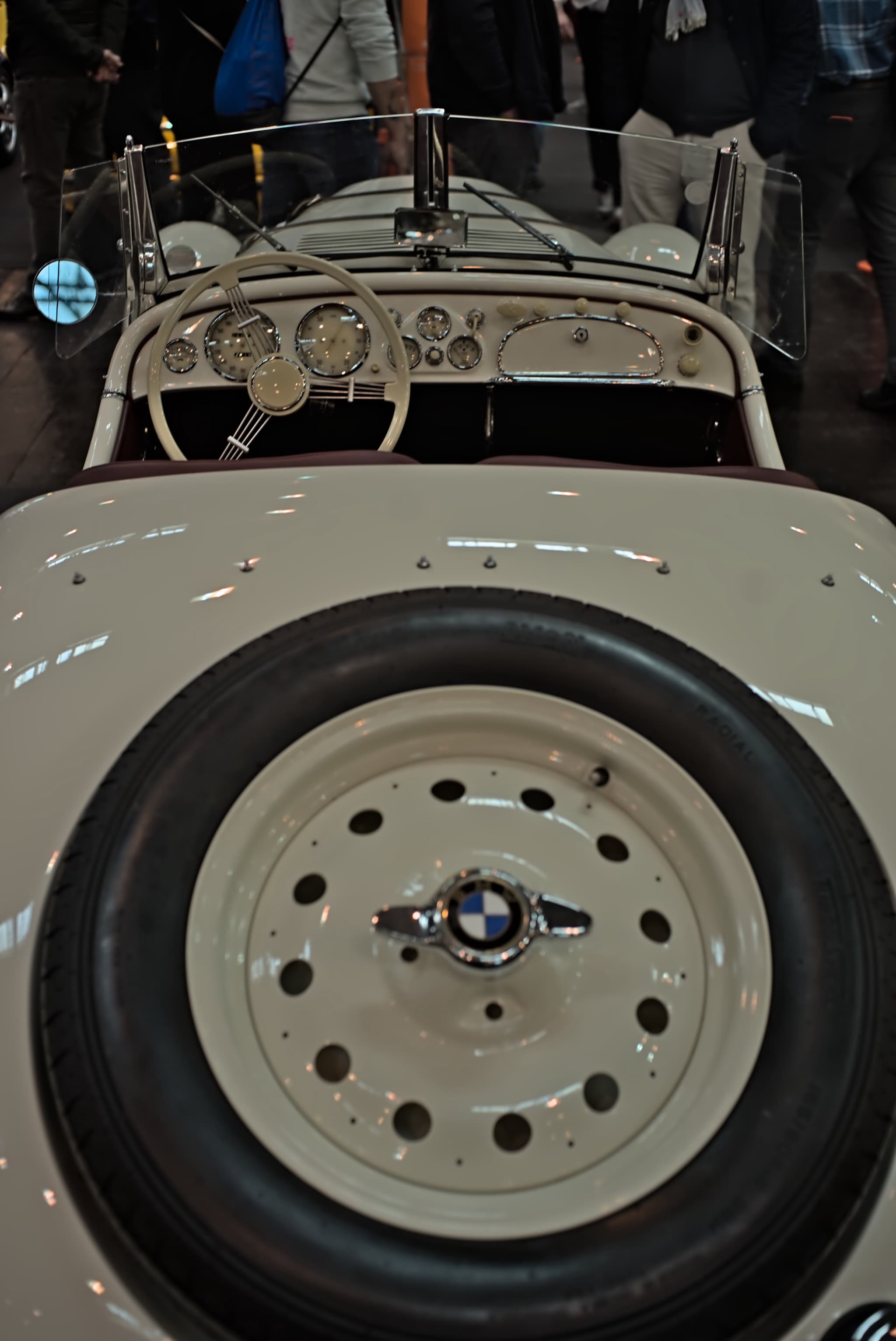 A white BMW 328 roadster seen from behind and above, its spare wheel in the tail, the cockpit and the vee windscreen beyond.